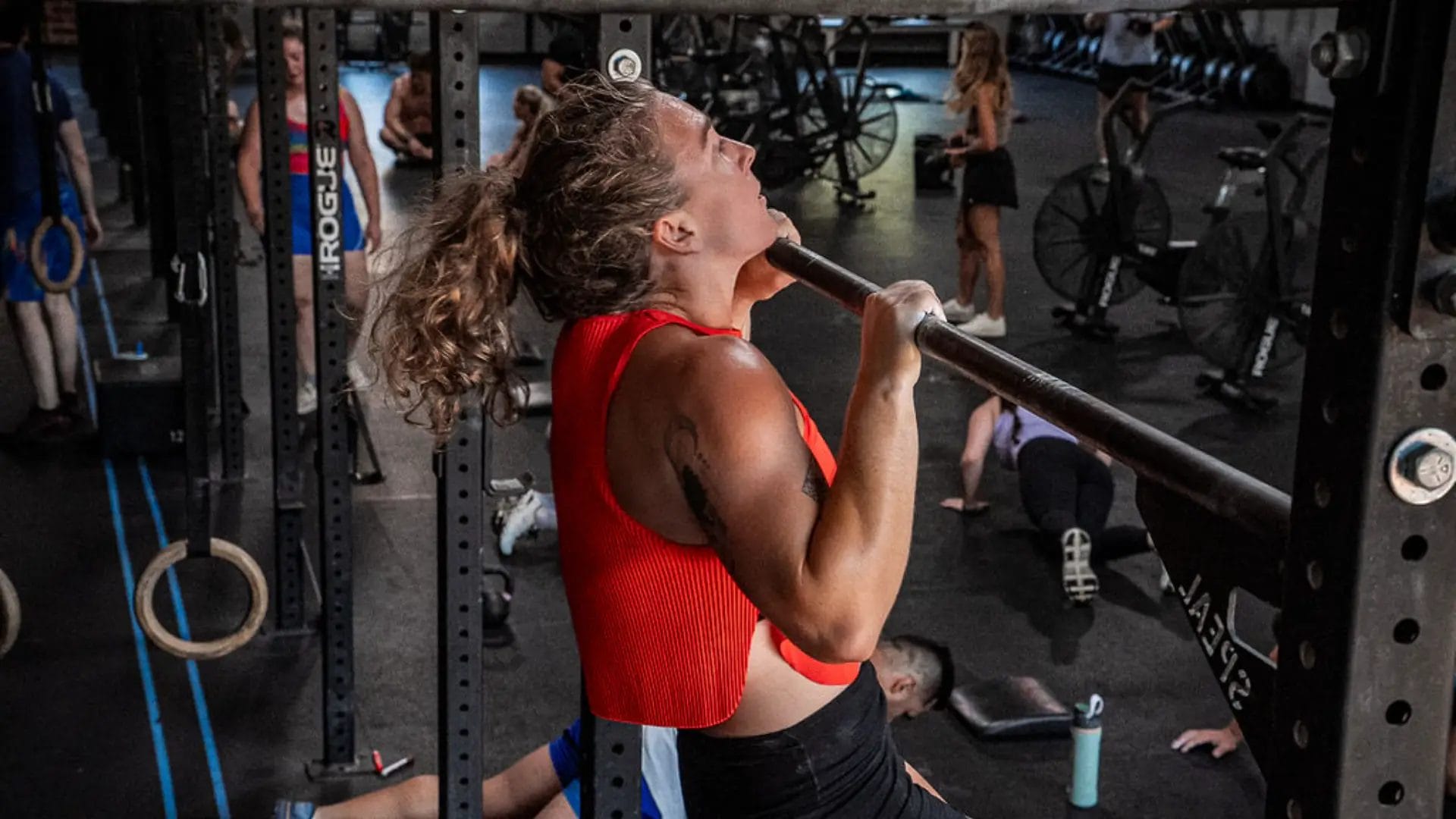 Woman performing pull ups during strength training at CrossFit Liberate gym